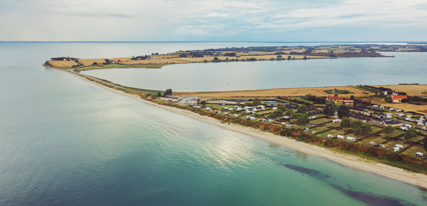 Drejby Strand Camping og dæmningen til Kegnæs set fra en drone