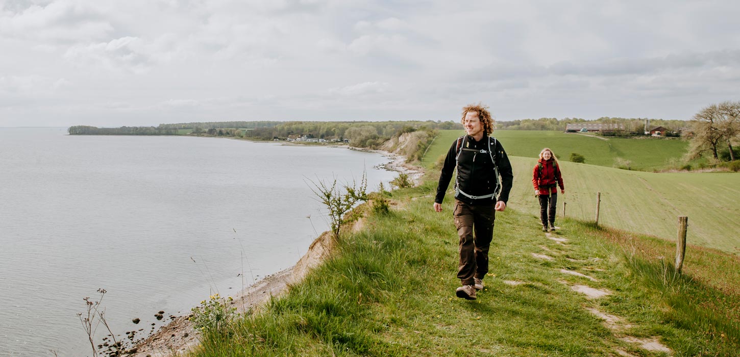 Paar wandelt op de Gendarmstien met uitzicht op Flensburg Fjord