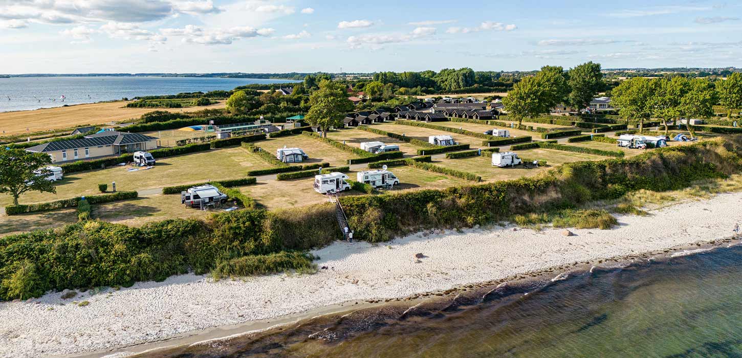 Dronefoto af Drejby Strand Camping med strand og vand på begge sider