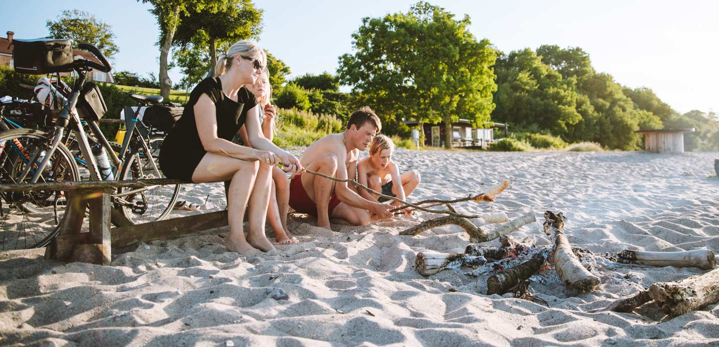 Familie på stranden med bål og cykler