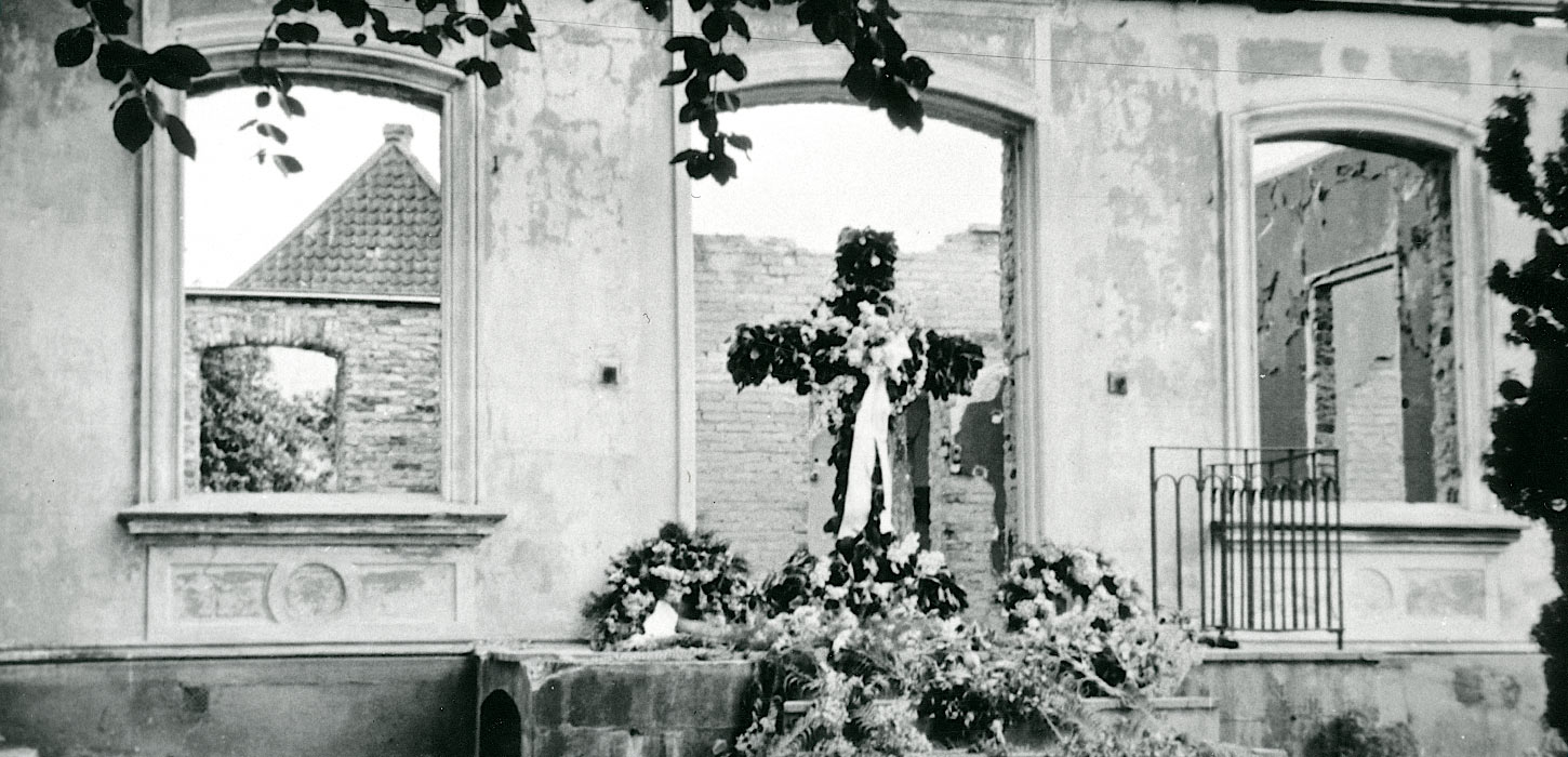 Paludan-Müller mindekors smykket med rødbøg og hvide bånd