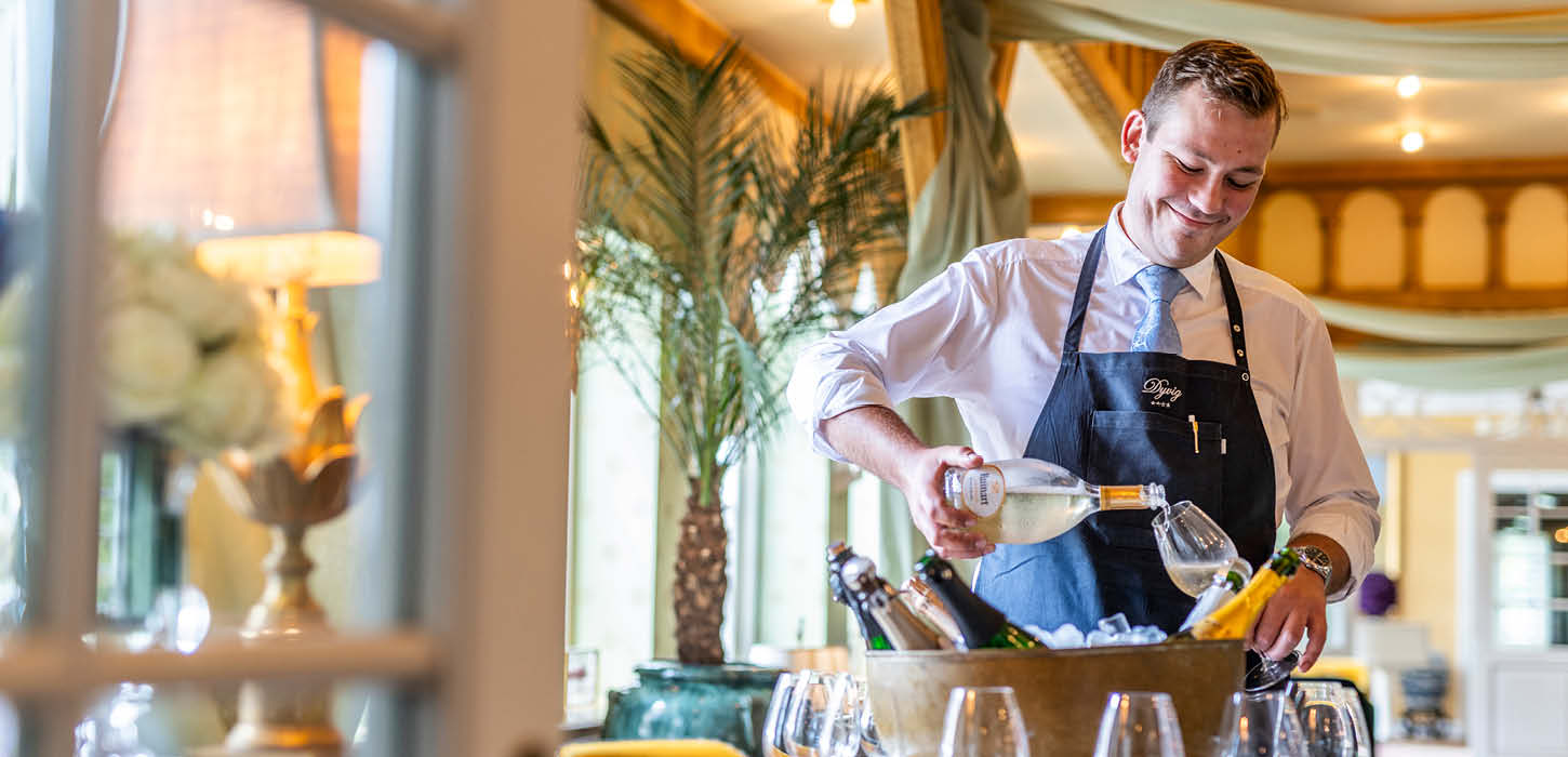 Tjener skænker vin på Dyvig Badehotel