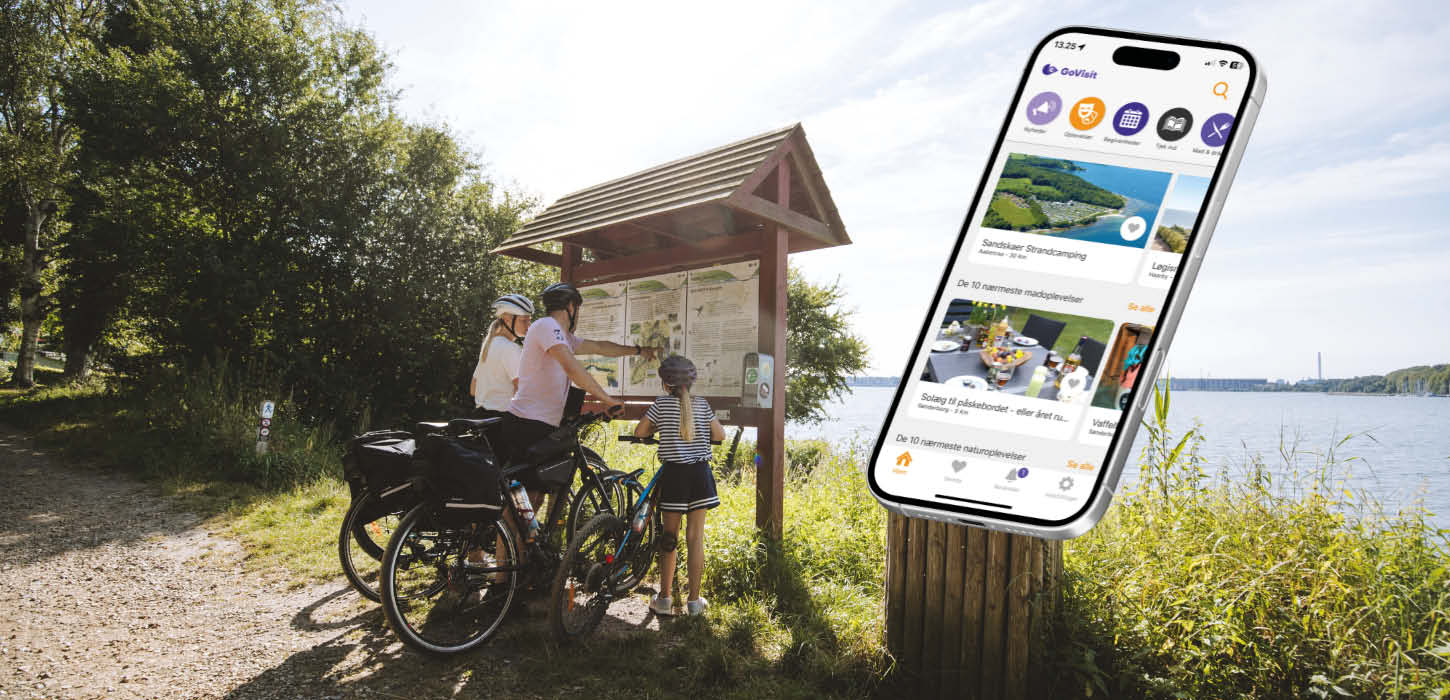 En familie står og kigger på et kort, og der er en mockup af en mobil med en åben app.