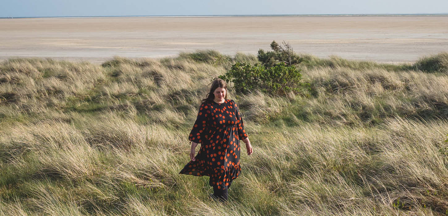 Kvinde der står i klitterne på stranden på Rømø