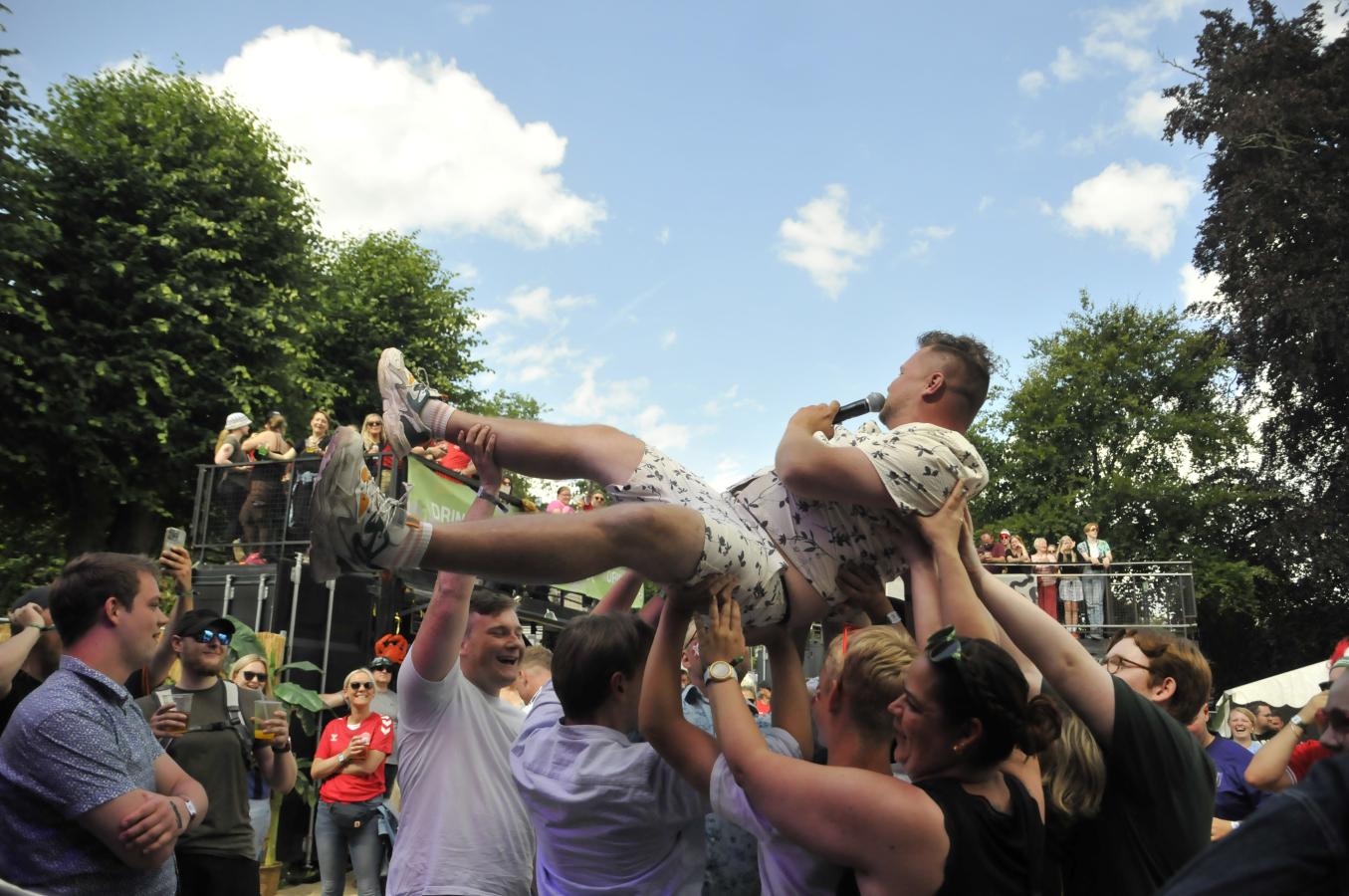 En af kunstnerne bliver båret på hænder gennem mængden.