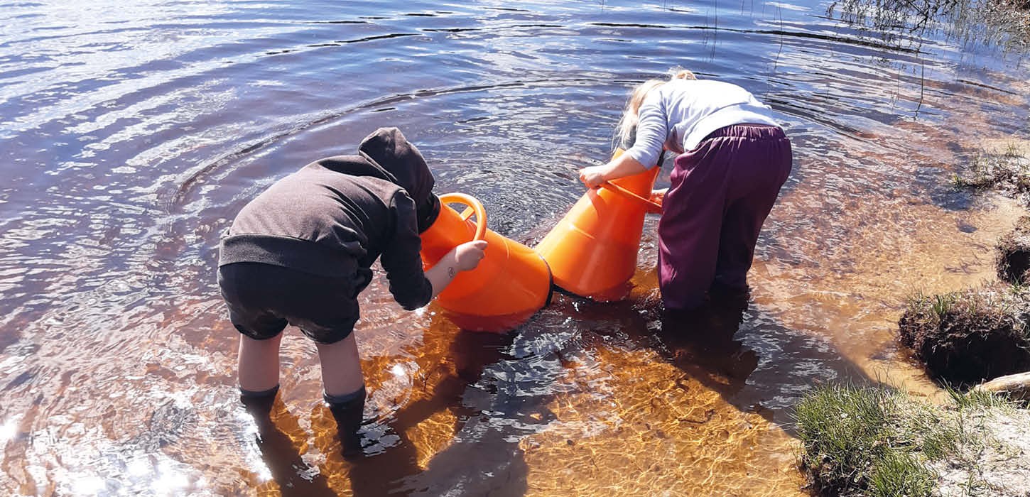 Børn leder efter mikroorganismer med mikroskoper med Naturcenter Tønnisgård
