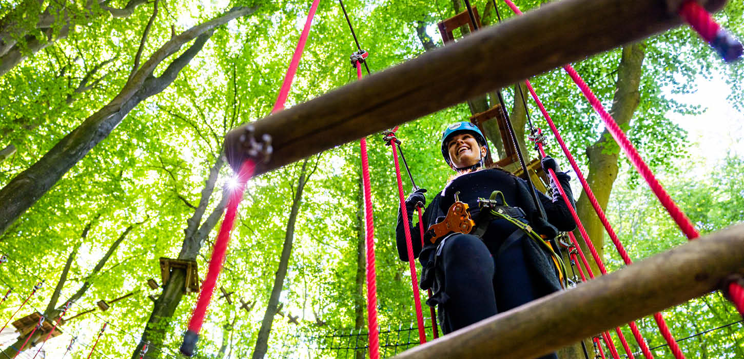 Kvinde på rød klatrebane ved Genner Hole