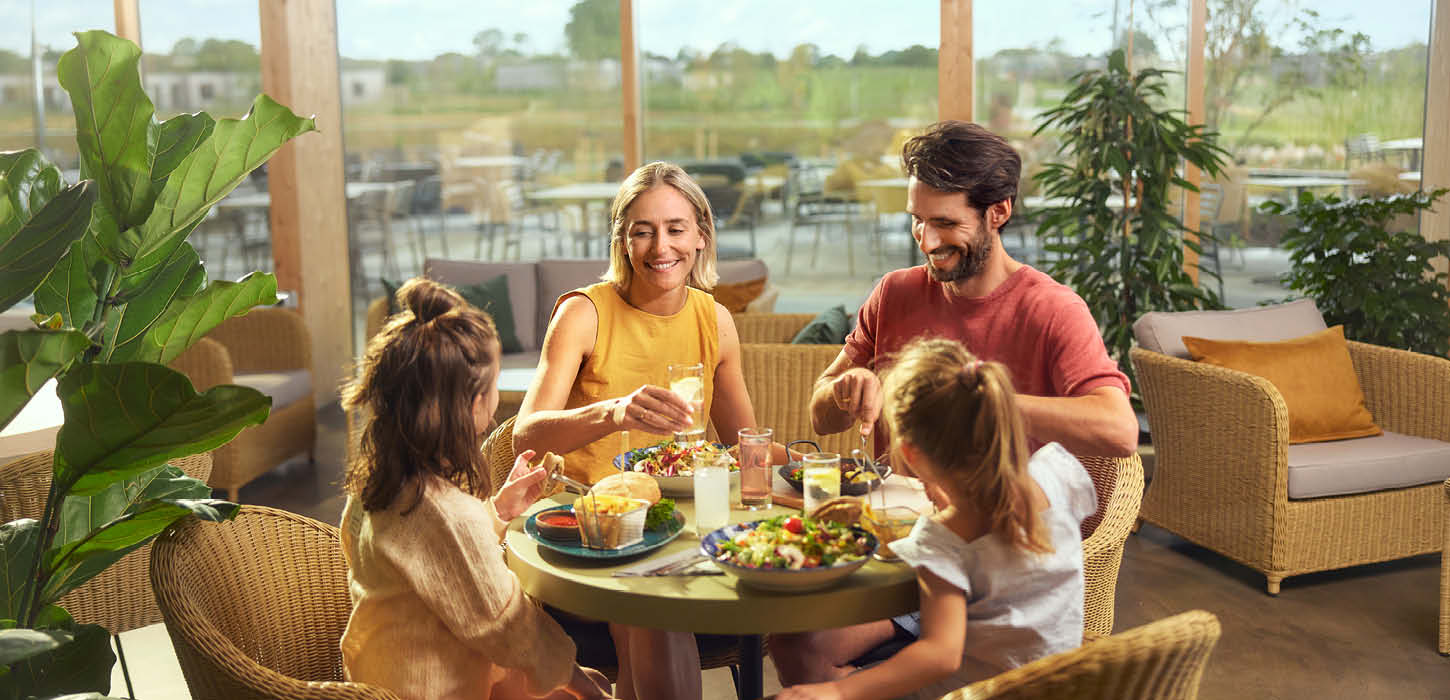 Børnefamilie nyder frokost i Market Dome i Center Parcs Nordborg Resort
