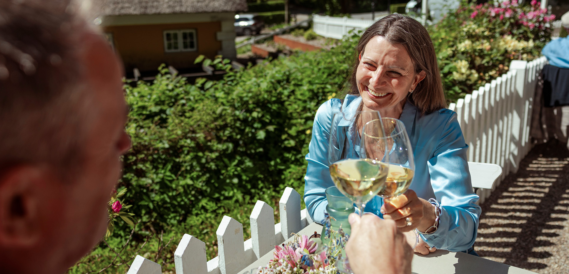 Par der skåler i hvidvin på udendørs restaurant