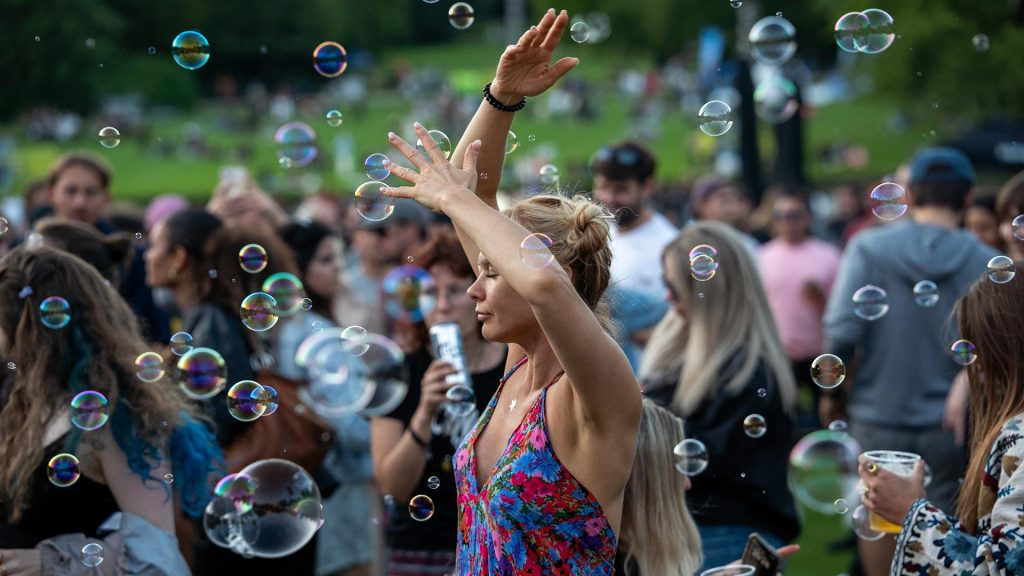 Kvinde danser imellem tilskuere og sæbebobler