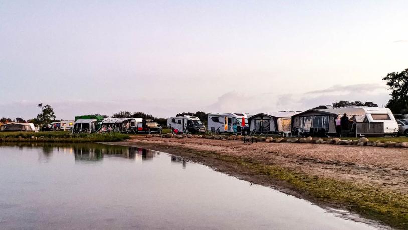 Caravans and campervans near the water at Lærkelunden Camping