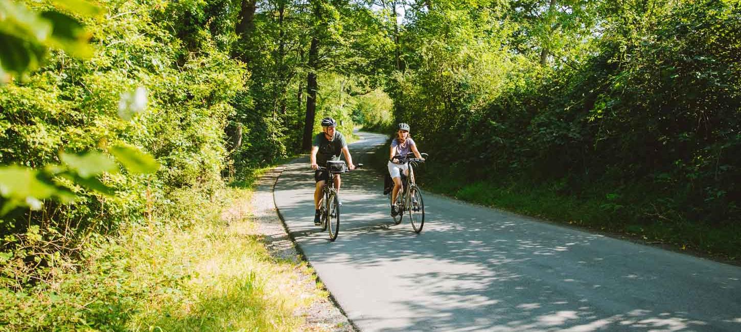 Ein Pärchen fährt Fahrrad im Wald um Aabenraa