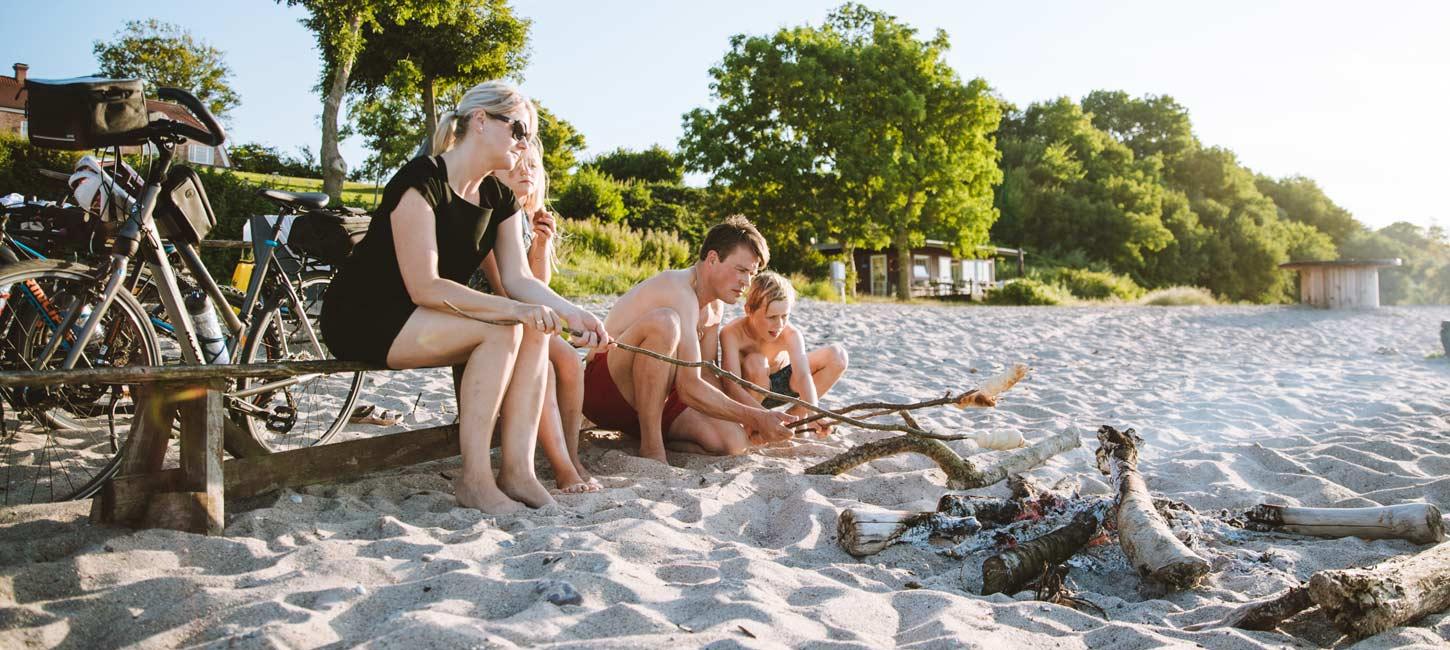 Family on the beach with bonfire and cycles