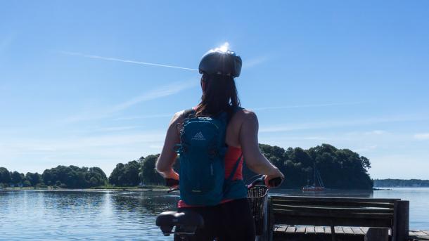 Kvinde med cykel kigger på Okseøerne i Flensborg Fjord