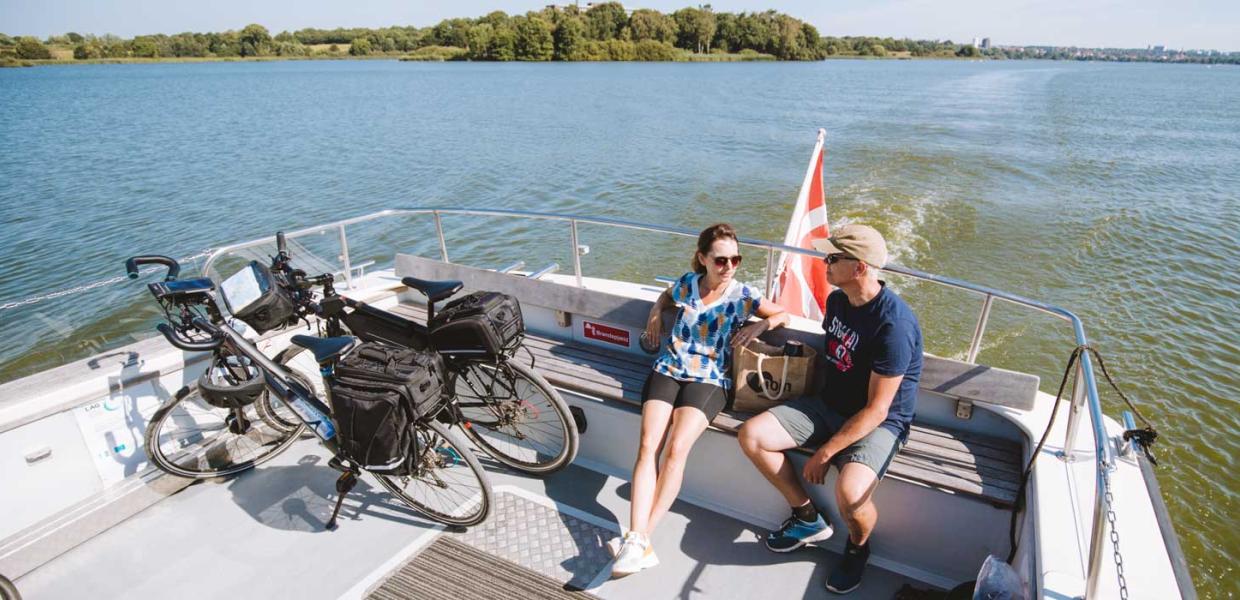 Par med cykler sidder ombord på Haderslev Dambåd