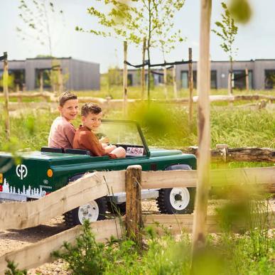 Forårsstemning. Børn der kører i små grønne biler i CPNR