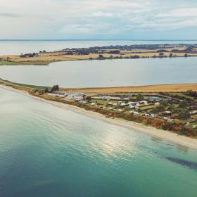 Drejby Strand Camping og dæmningen til Kegnæs set fra en drone