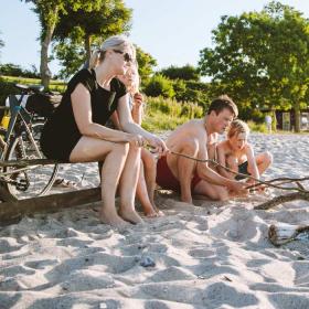 Family on the beach with bonfire and cycles