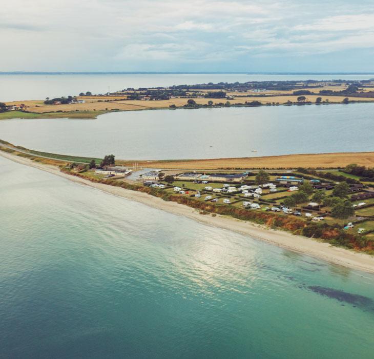 Drejby Strand Camping og dæmningen til Kegnæs set fra en drone